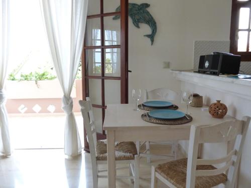 a white dining room with a table and chairs at Romanza in Kalamaki