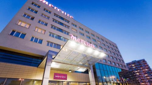 a large hotel building with a sign on it at Hotel Mercure Toruń Centrum in Toruń