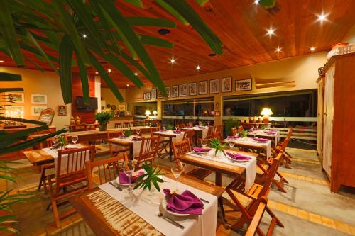 - un restaurant avec des tables et des chaises dans une salle dans l'établissement Pousada Villas da Serra, à Serra de São Bento