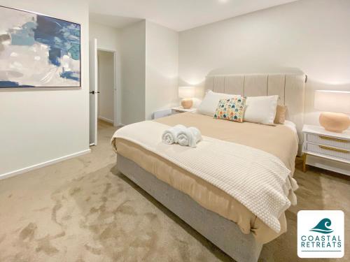 a bedroom with a bed with two towels on it at Rilley Retreat Inverloch, Luxe Townhouse Near Beach in Inverloch