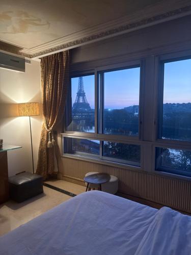 a bedroom with a bed and a view of the eiffel tower at Les Amoureux de Paris in Paris