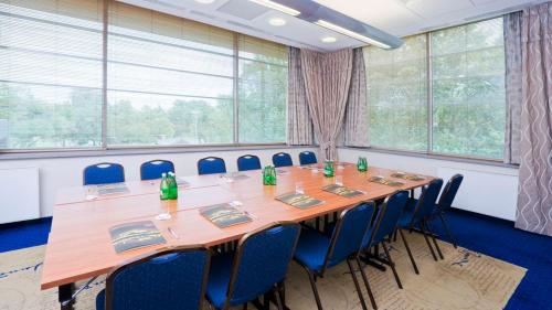 a conference room with a long wooden table and chairs at Hotel Mercure Toruń Centrum in Toruń