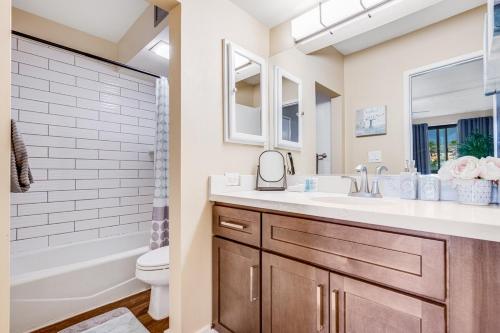 a bathroom with a sink and a toilet and a tub at Private Lanai! - AC -5 minute walk from beach! in Lahaina