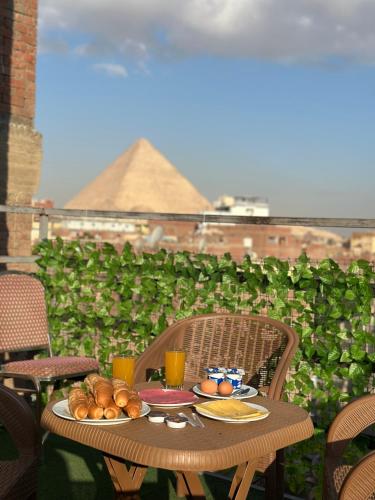 una tavola con cibo sopra con vista su una piramide di Great Pyramids view Lodge a Il Cairo