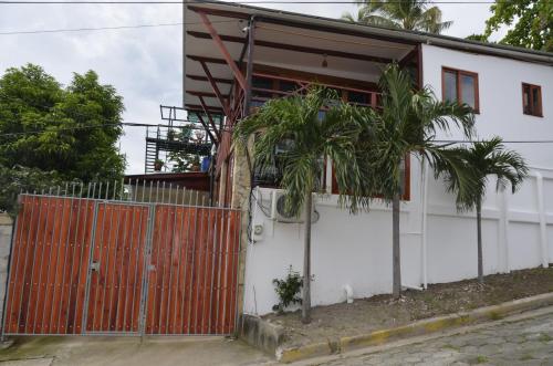 a house with a gate and trees in front of it at Nuestra Casa in San Juan del Sur