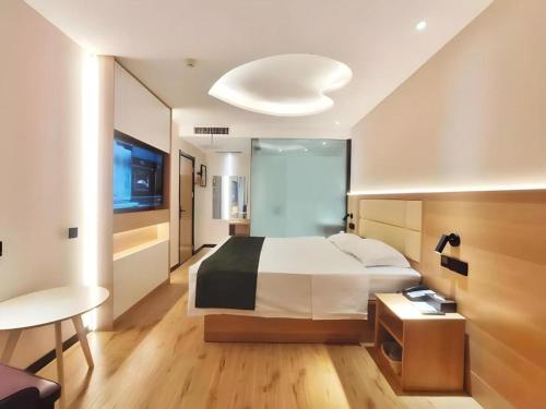 a hotel room with a bed and a table and a bed sidx sidx at GreenTree Inn Heze Railway Station Hotel in Heze