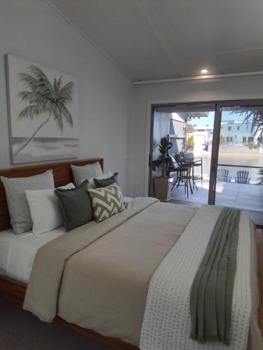 a bedroom with a large bed and a balcony at Studio 21 Waterfront in Yamba