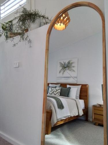a bedroom with a bed and a large mirror at Studio 21 Waterfront in Yamba