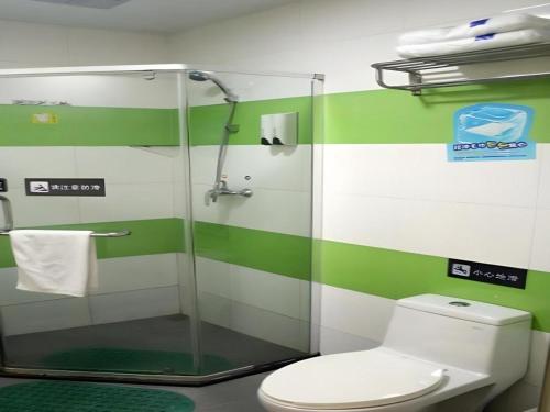 a green and white bathroom with a toilet and a shower at 7 Days Inn Bijie Jinsha Hebin Road in Jinsha