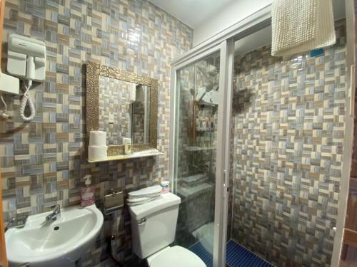 a bathroom with a toilet and a sink and a shower at MDM Hotel in Cordova