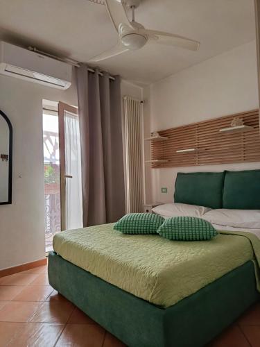 a bedroom with a green bed with two pillows on it at Lydian Suite in Bari