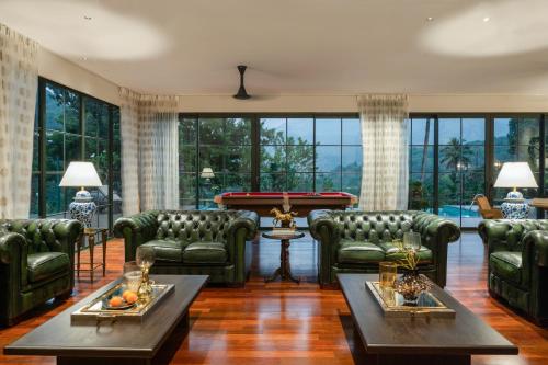 a living room with couches and a pool table at The Ranch Kakkadampoyil - a VKation Experience in Kakkadampoyil