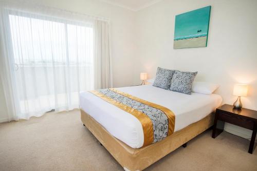 a bedroom with a large bed and a window at Gladstone City Central Apartment Hotel Official in Gladstone