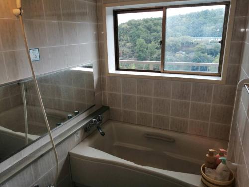 a bathroom with a bath tub and a window at Fujiya in Sango