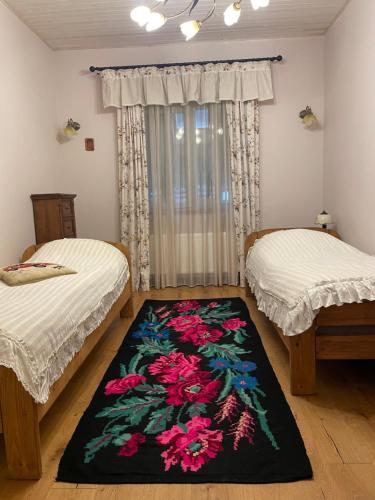 a room with two beds and a rug on the floor at Relaxation in Guta Гута покращене шале in Guta