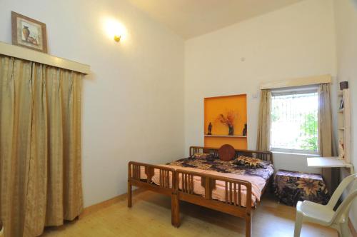 a small bedroom with a bed and a window at Jheelam Homestay in Bhopal