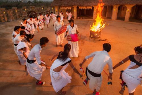 a group of people dancing around a bonfire at Meghauli Serai Chitwan National Park - A Taj Safari Lodge in Meghauli