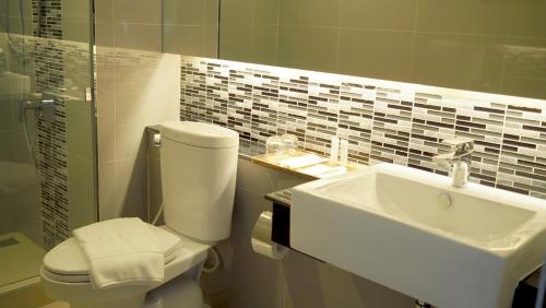 a bathroom with a toilet and a sink at Chaisaeng Villa in Sing Buri