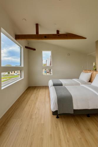 a bedroom with two beds and a large window at The Lobs Toya, Chalet Secca in Lake Toya