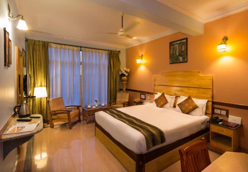 a hotel room with a bed and a desk at Hotel Presidency Kempegowda International Airport Bangalore in Devanahalli-Bangalore