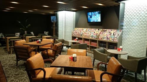 a restaurant with tables and chairs and a tv at Gran Customa Isezakicho in Yokohama