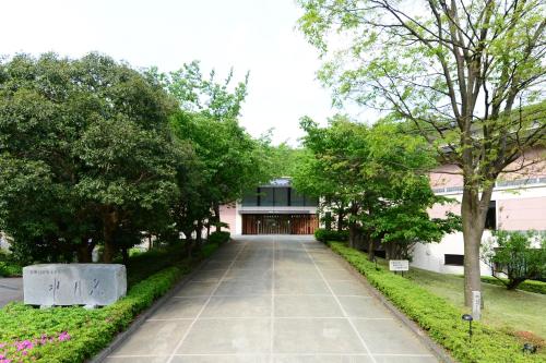 a walkway in front of a building with trees at Suigekka in Wakasa