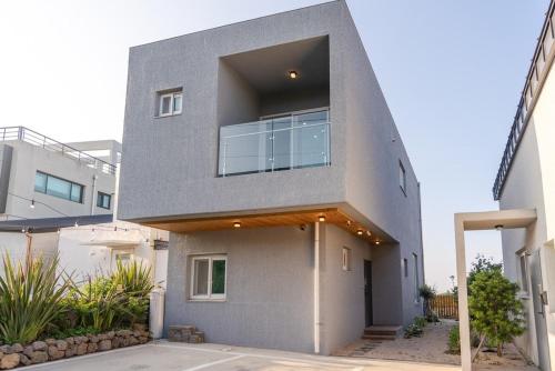 a house with a large window on the side of it at Jeju Stayra in Sowang-dong