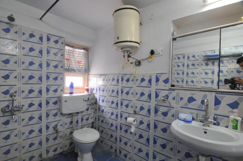 a bathroom with a blue and white tiled wall at Jheelam Homestay in Bhopal