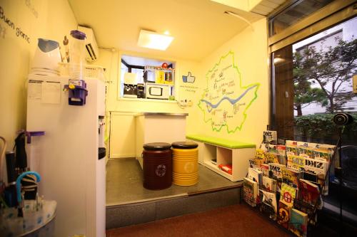 ソウルにあるコステイ ゲストハウス ソウル ステーションのゴミ箱2つと冷蔵庫が備わる部屋