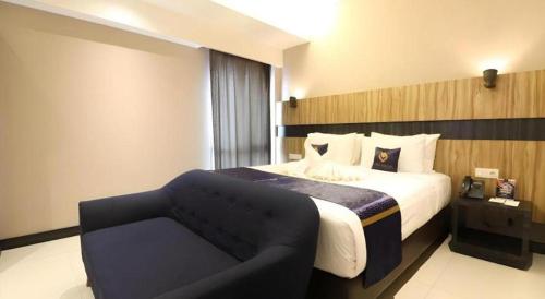 a hotel room with a bed and a chair at Fitra Hotel Majalengka in Majalengka