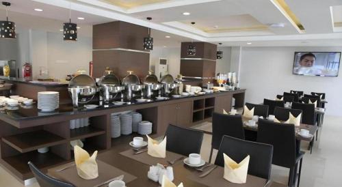 DemarkにあるAmantis Hotelのテーブルと椅子とカウンターのあるレストラン