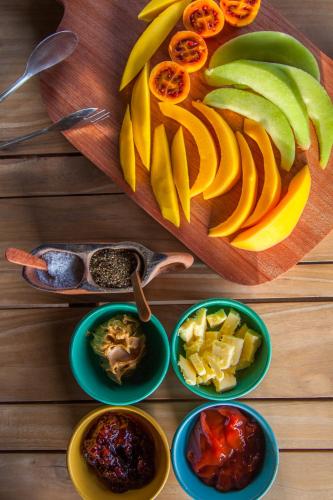 a wooden table with bowls of fruit on a cutting board at Ololo Safari Lodge & Farm in Nairobi