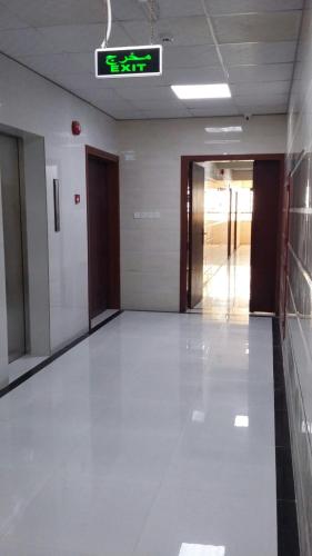 an empty hallway in a building with a clock on the wall at Serapis Hotel in Ḩilf