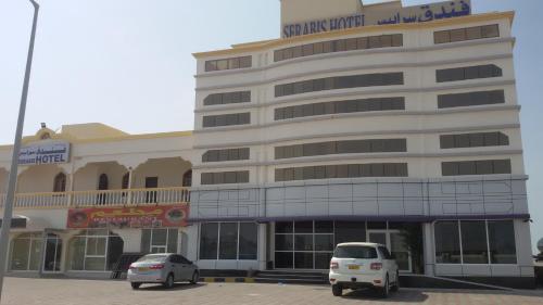 a building with two cars parked in front of it at Serapis Hotel in Ḩilf
