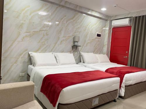 a bedroom with two beds and a red door at MDM Hotel in Cordova