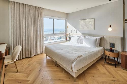 a bedroom with a large bed and a large window at Jewel TLV Hotel in Tel Aviv