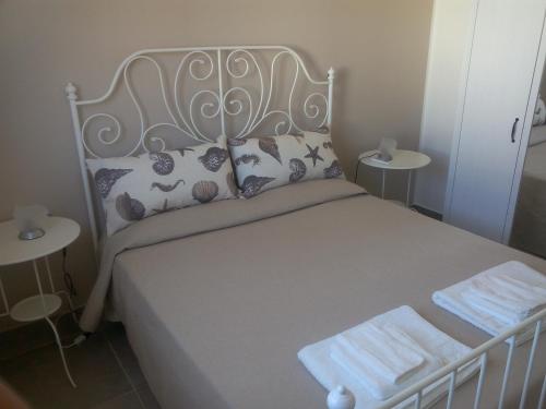 1 dormitorio con 1 cama blanca y 2 mesas en Eucalipto new private pool, en Castellammare del Golfo
