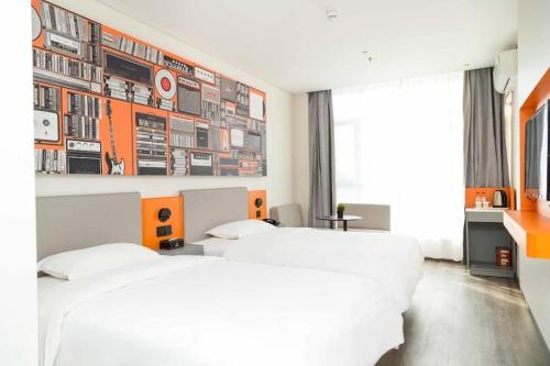 a bedroom with two beds and a wall with pictures at ibis Tianjin Wuqing Hotel in Tianjin