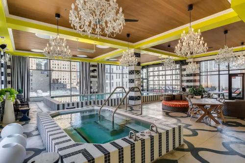 a hotel lobby with a pool and chandeliers at CBD Apartment Pool 24-7 Gym Parking in Cincinnati