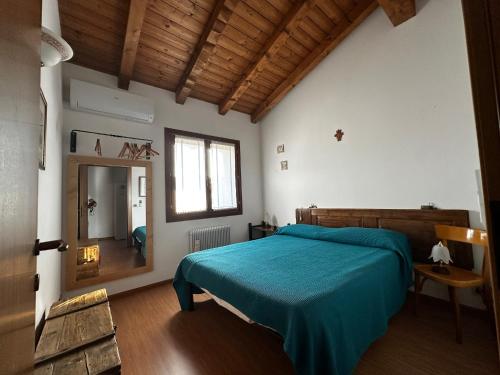 a bedroom with a blue bed and a mirror at Ca' Teresa in Ravosa