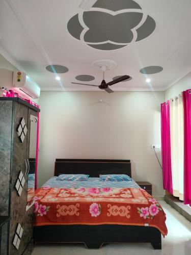 a bedroom with a bed with a ceiling fan at Shiva Homestay in Rishīkesh