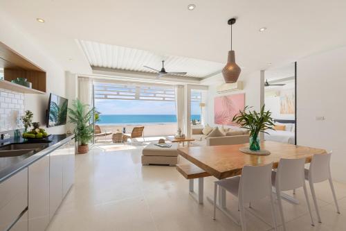 a kitchen and living room with a table and chairs at Aqua Villas Seaview Chaweng Noi in Nathon Bay