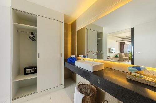 a bathroom with a sink and a mirror at Aqua Villas Seaview Chaweng Noi in Amphoe Koh Samui