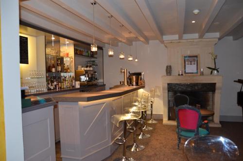a bar with chairs and a fireplace in a room at Hotel et Spa Les Cleunes Oléron in Saint-Trojan-les-Bains