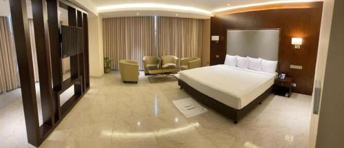a hotel room with a bed and a chair at Hotel Tower Inn, Chittagong in Chittagong