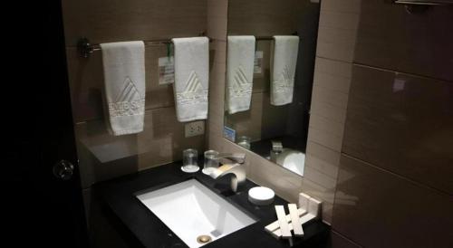バコロドにあるAvenue Suitesの洗面台と鏡のあるバスルーム