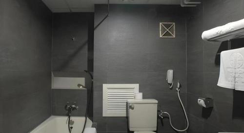 a bathroom with a shower and a toilet and a phone at Huu Nghi Hotel in Hai Phong
