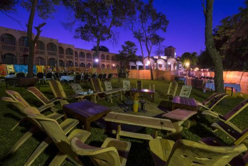 a group of chairs and tables in a yard at night at Victoria Falls Rainbow Hotel in Victoria Falls