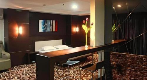 a room with a desk with a vase of flowers on it at 89 Hotel Batam in Nagoya