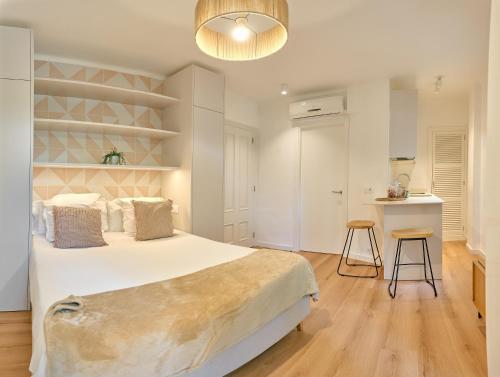 a bedroom with a large bed and a kitchen at Lavendel Apartments in Colonia Sant Jordi